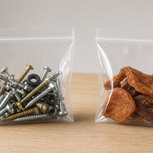 Bolsas con zipper selladas con tornillería y fruta seca sobre madera clara