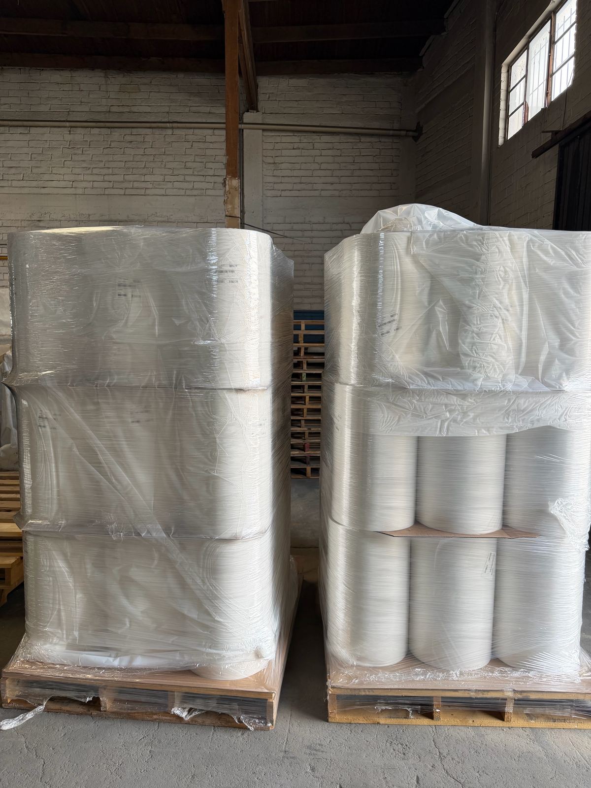 Pallets with stretch wrapped heat shrink film rolls